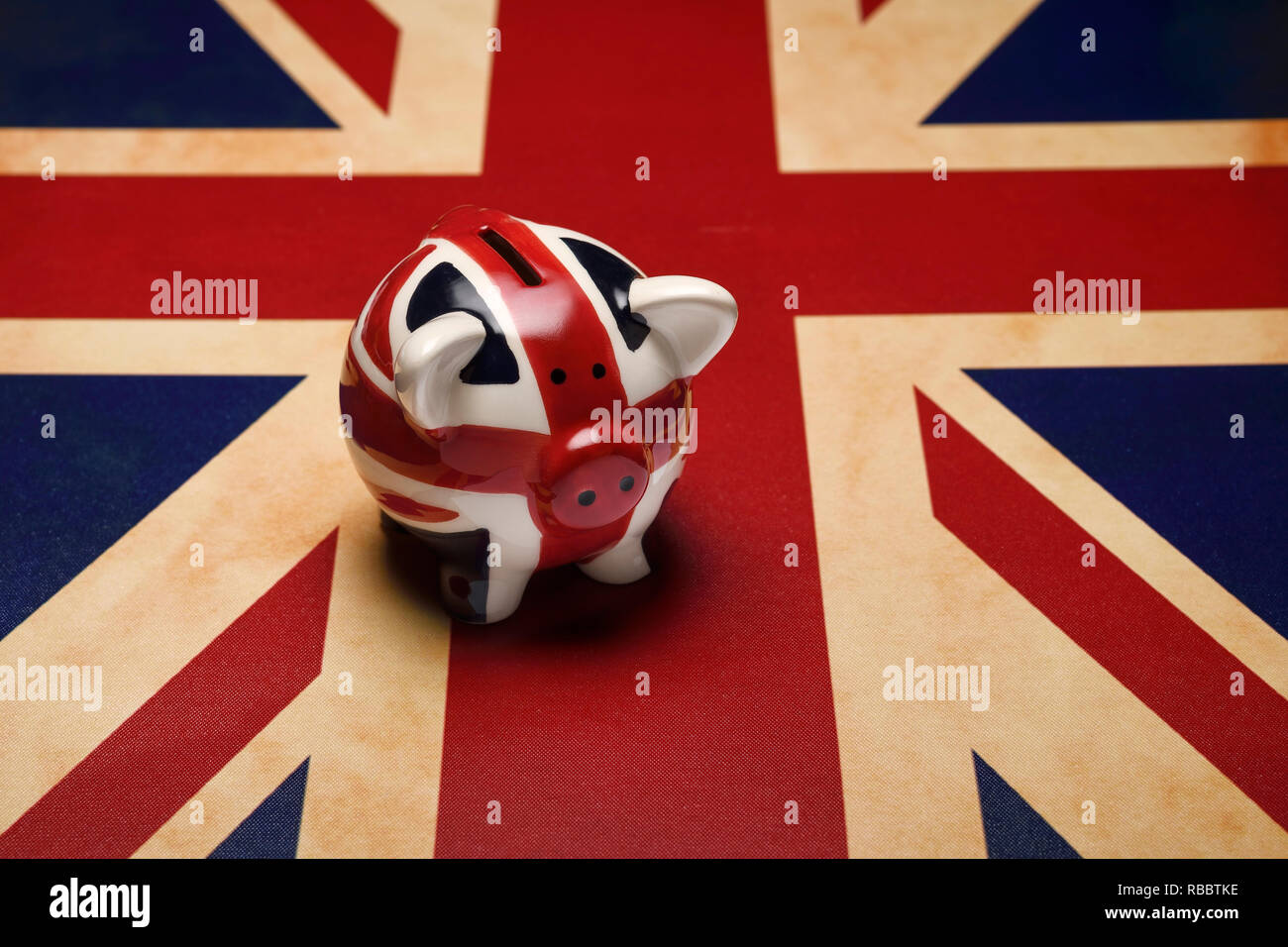 A piggy bank sitting on a Union Jack flag Stock Photo