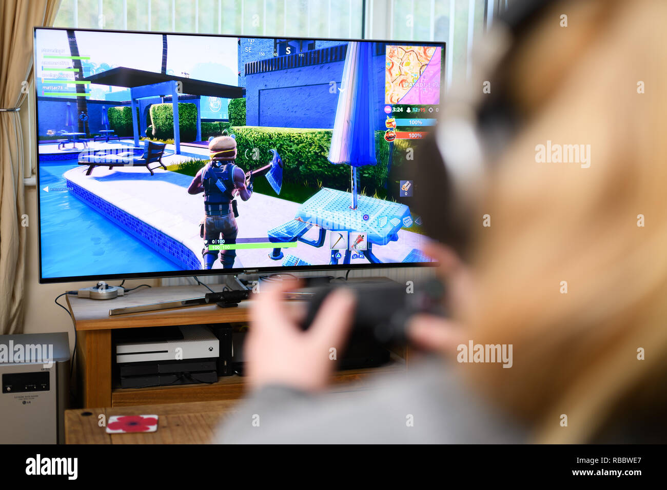 Cardiff, Wales - January 09, 2019: Teenager Girl playing Fortnite video game, Fortnite is a web based multi player survival game developed by Epic Gam Stock Photo