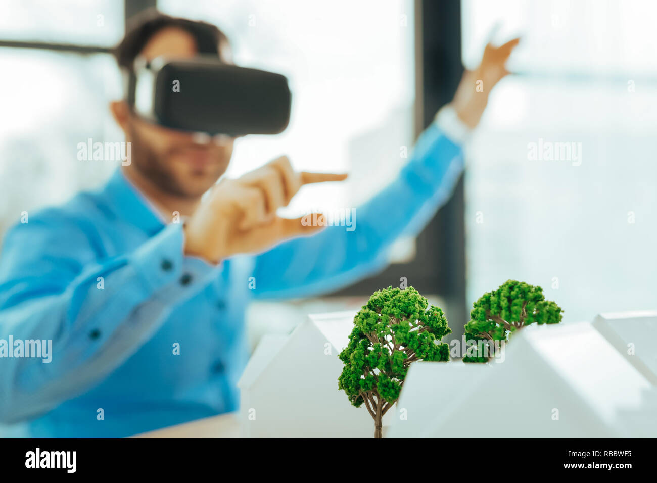 Miniature trees. Positive clever engineer carefully measuring the ...