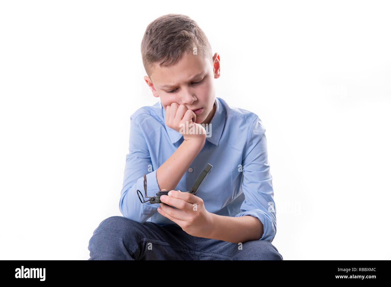 Boy brooding over his future sitting with a compass in his hand and ...