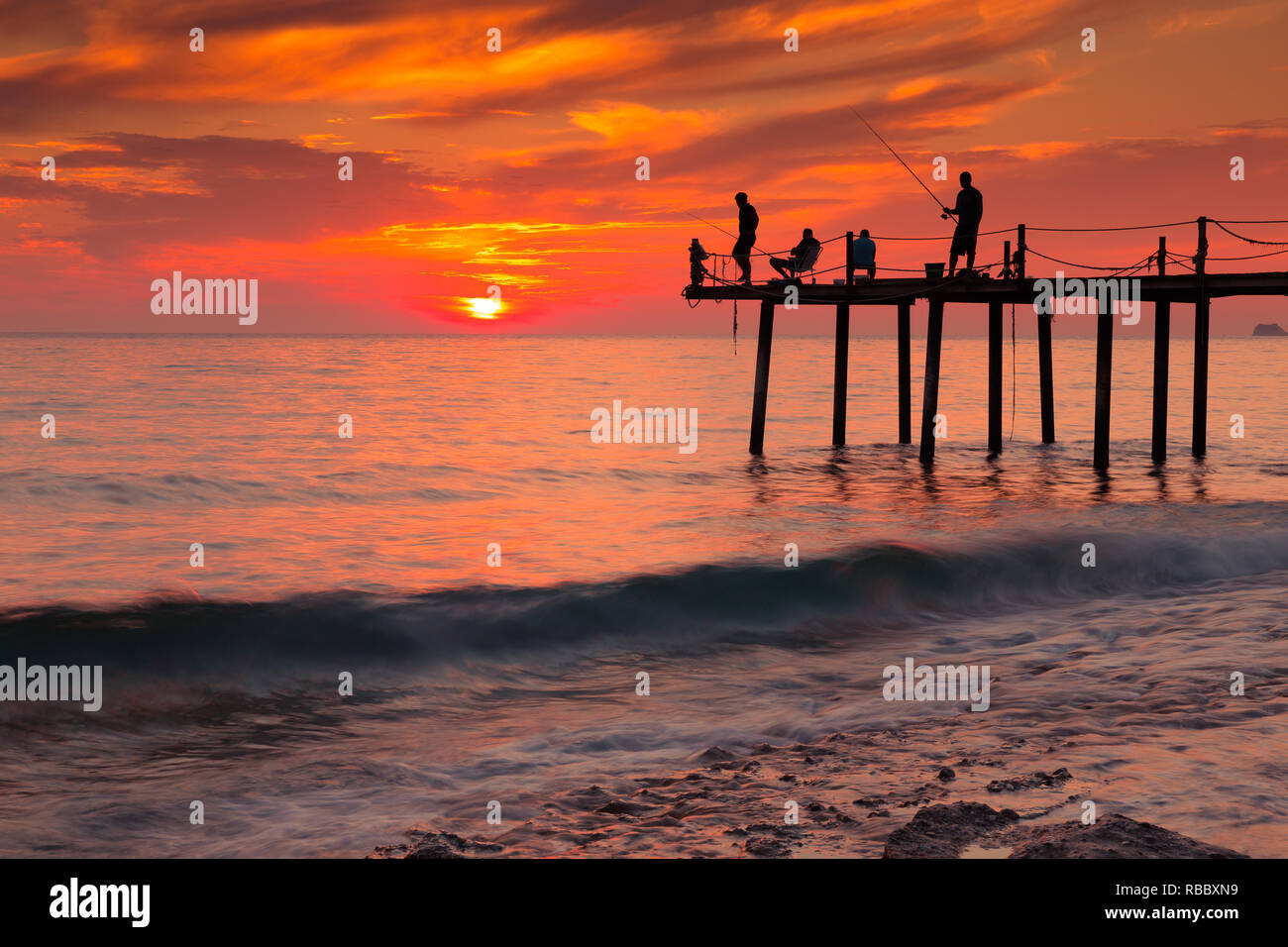 Silhouettes of fishermen on the pier Stock Photo - Alamy
