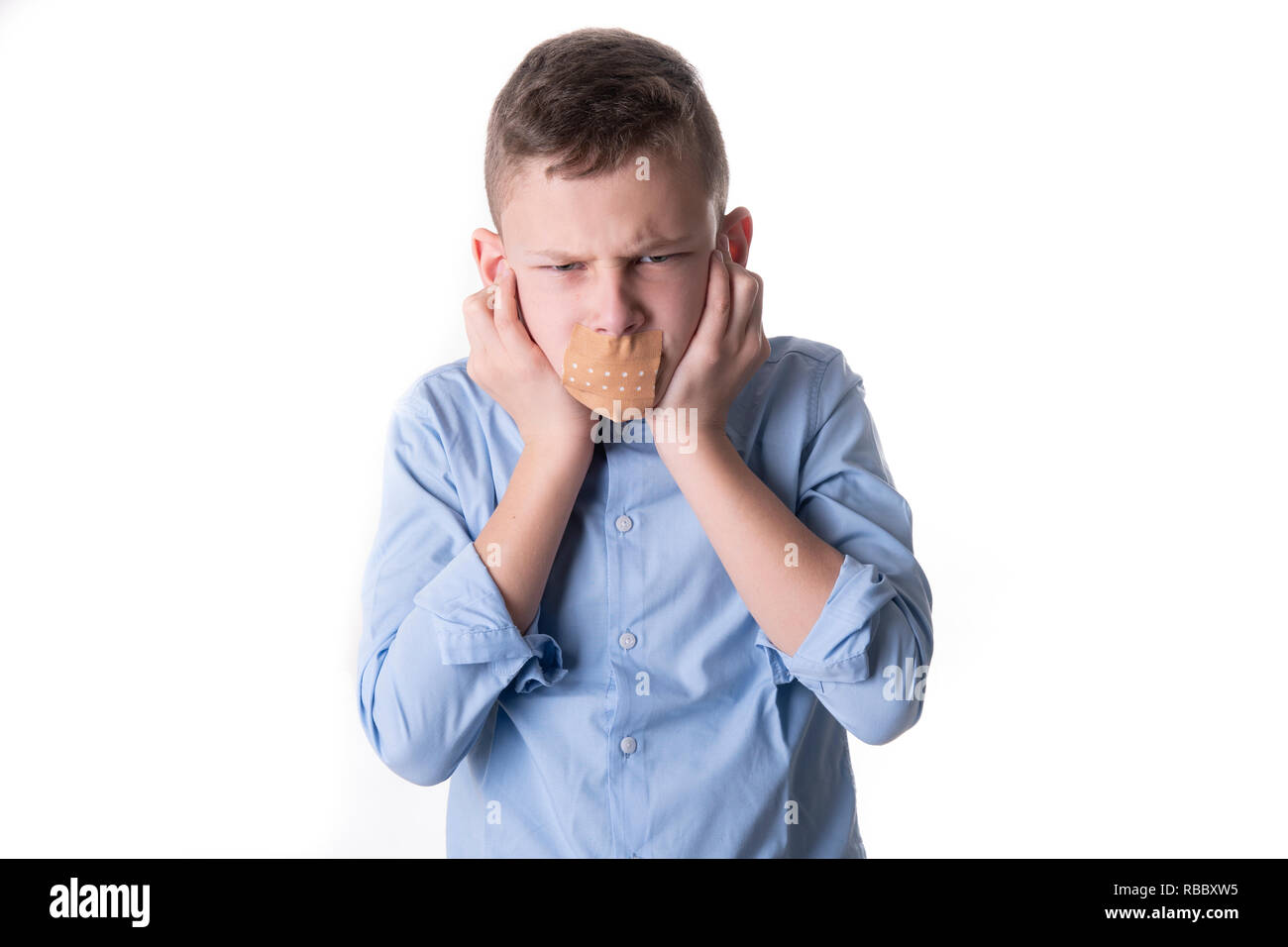 Child speechless with a plaster over his mouth also holds his ears to