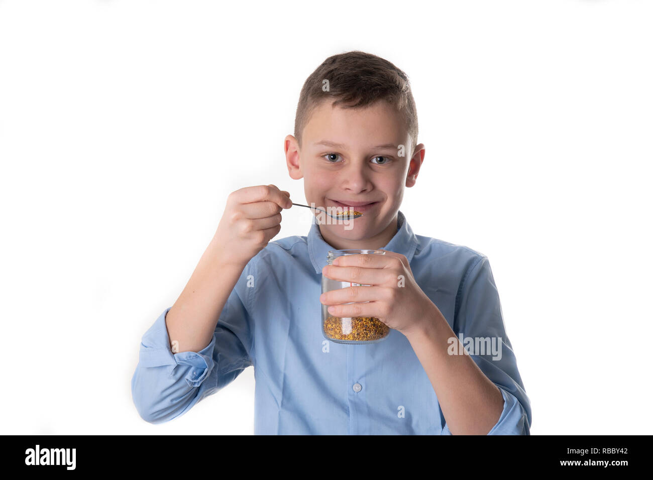 Boy takes propolis from bees with a spoon to stay healthy Stock Photo