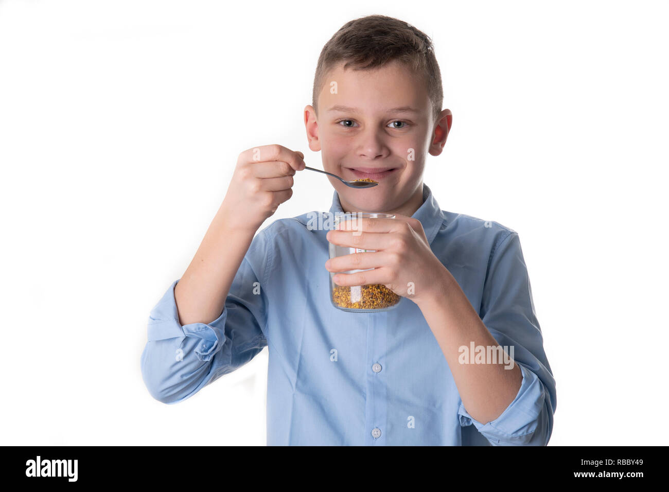 Boy takes propolis from bees with a spoon to stay healthy Stock Photo