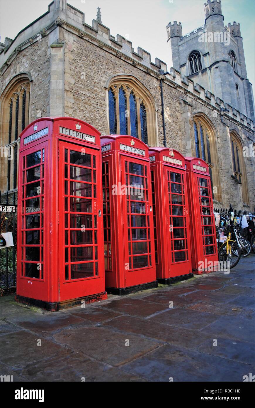4 British red telephone e boxes outside a church in Cambridge city centre Stock Photo