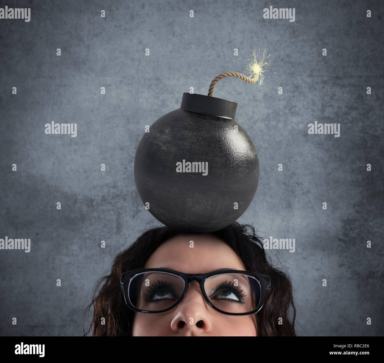 Businesswoman stunned by strong headache with a bomb over the head Stock Photo