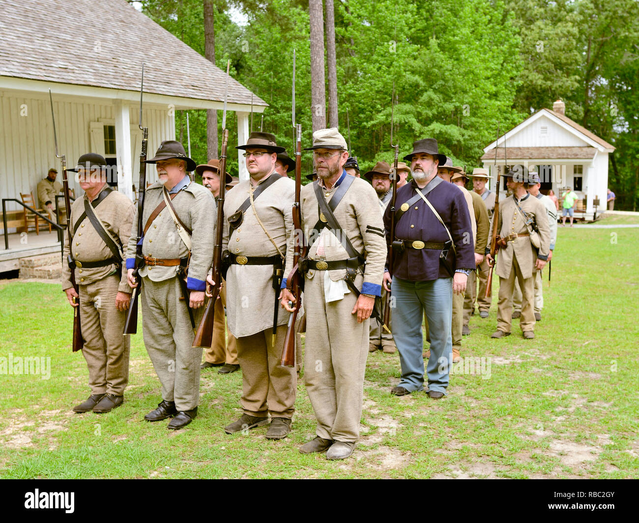 American Civil War reenactment soldiers in Confederate and Union uniforms stand in formation at battle recreation in Marbury Alabama USA. Stock Photo