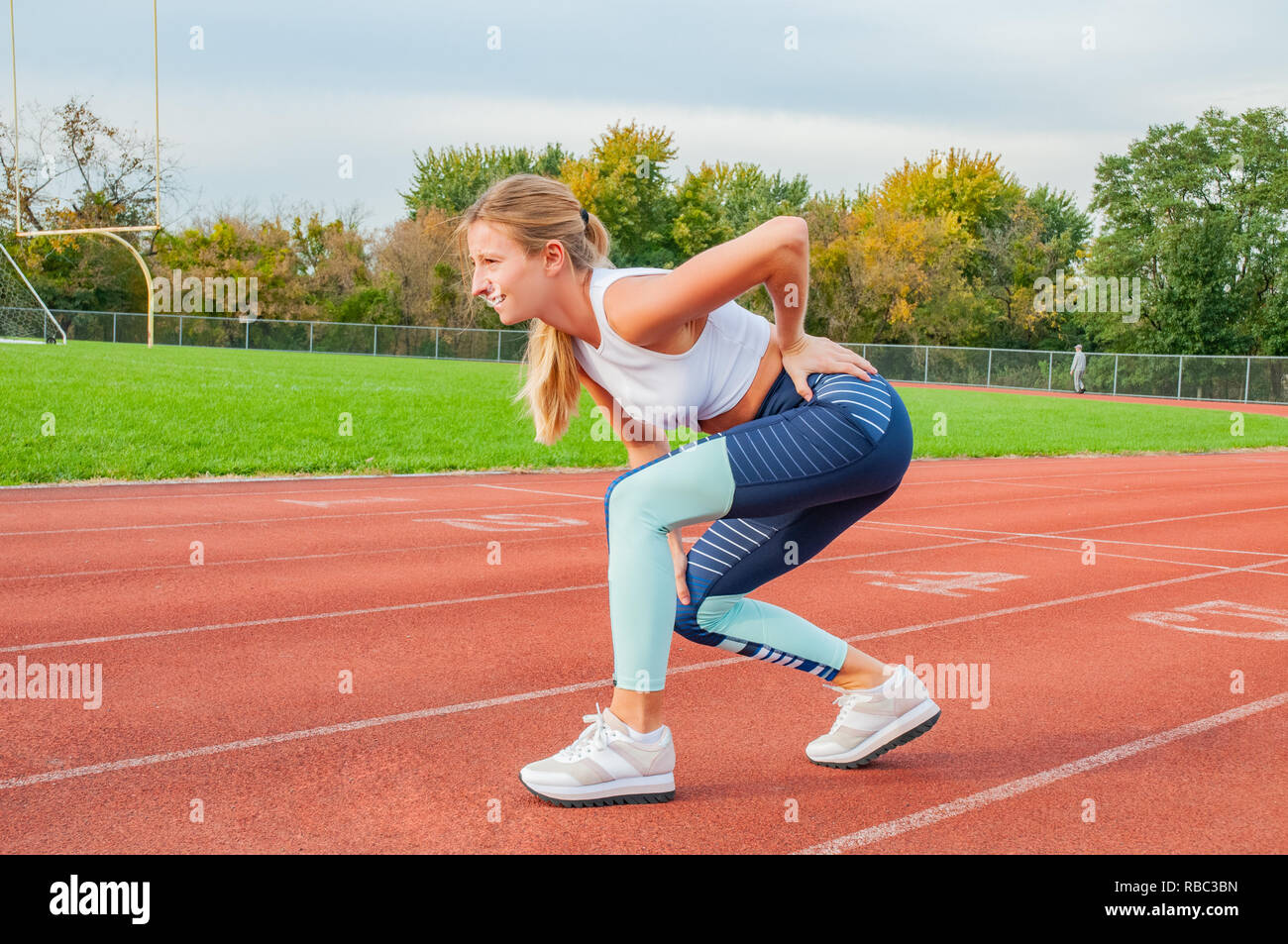 Back pain. Fitness running woman with injury in sportswear rubbing