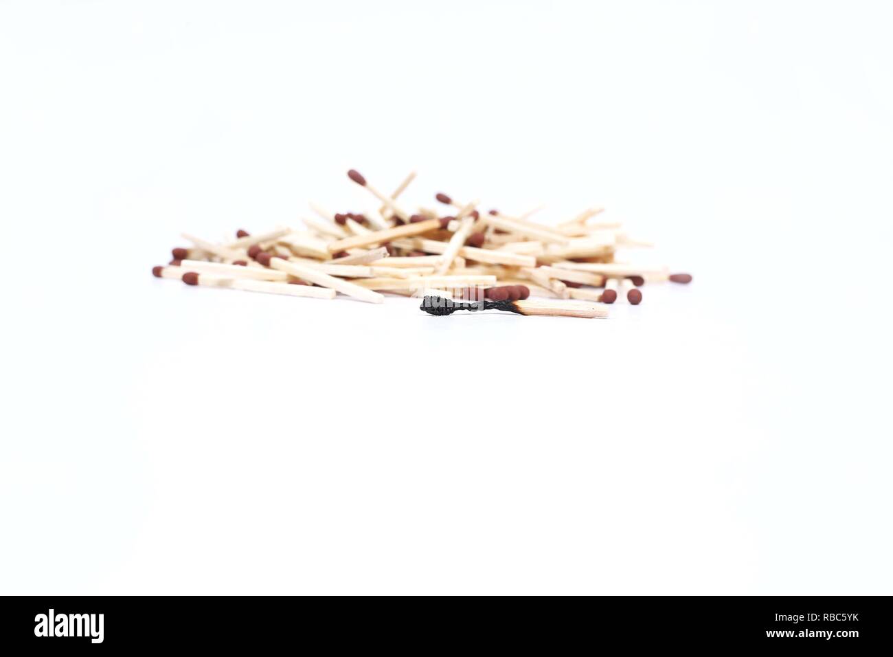 Picture of pile wooden matches with one burnt matches. Isolated on the white background. Stock Photo