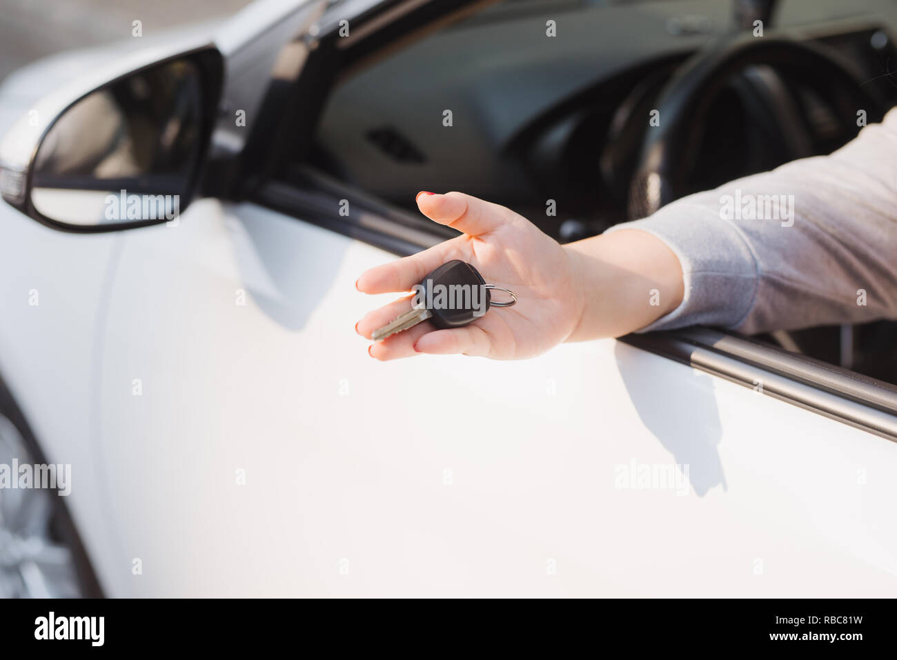 Woman holding the ignition keys of a car in her hand dangling them