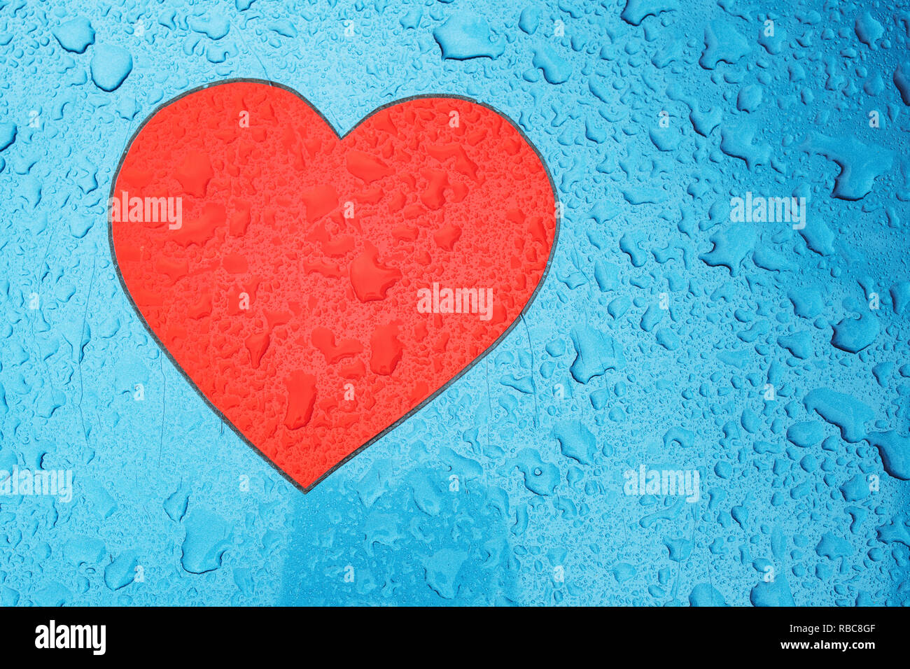 Heart shape symbol and raindrops on metal surface, love and romance concept Stock Photo