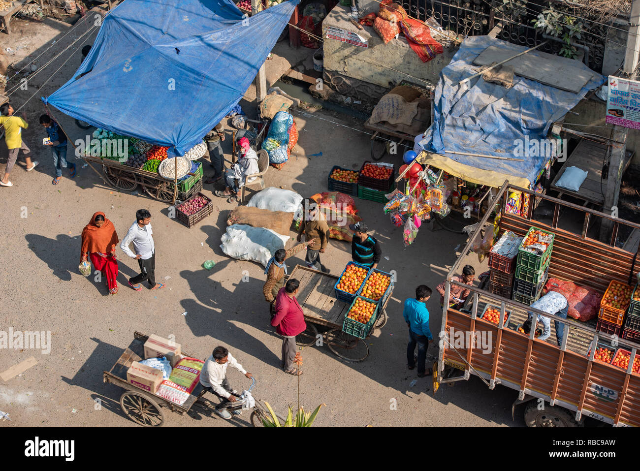 Market stalls are being loaded with fresh produce in preparation for the day ahead in the marketplace in JJ Colony Madanpur Khadar, New Delhi, India Stock Photo