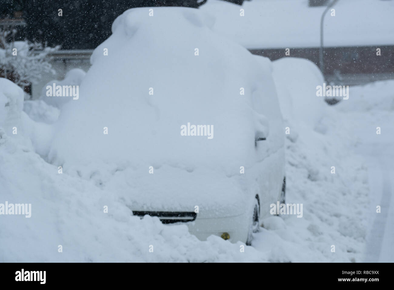 Snow on cars after snowfall. Winter urban scene. Car is complete covered. Chaos and catastophe alert in bavaria germany Stock Photo