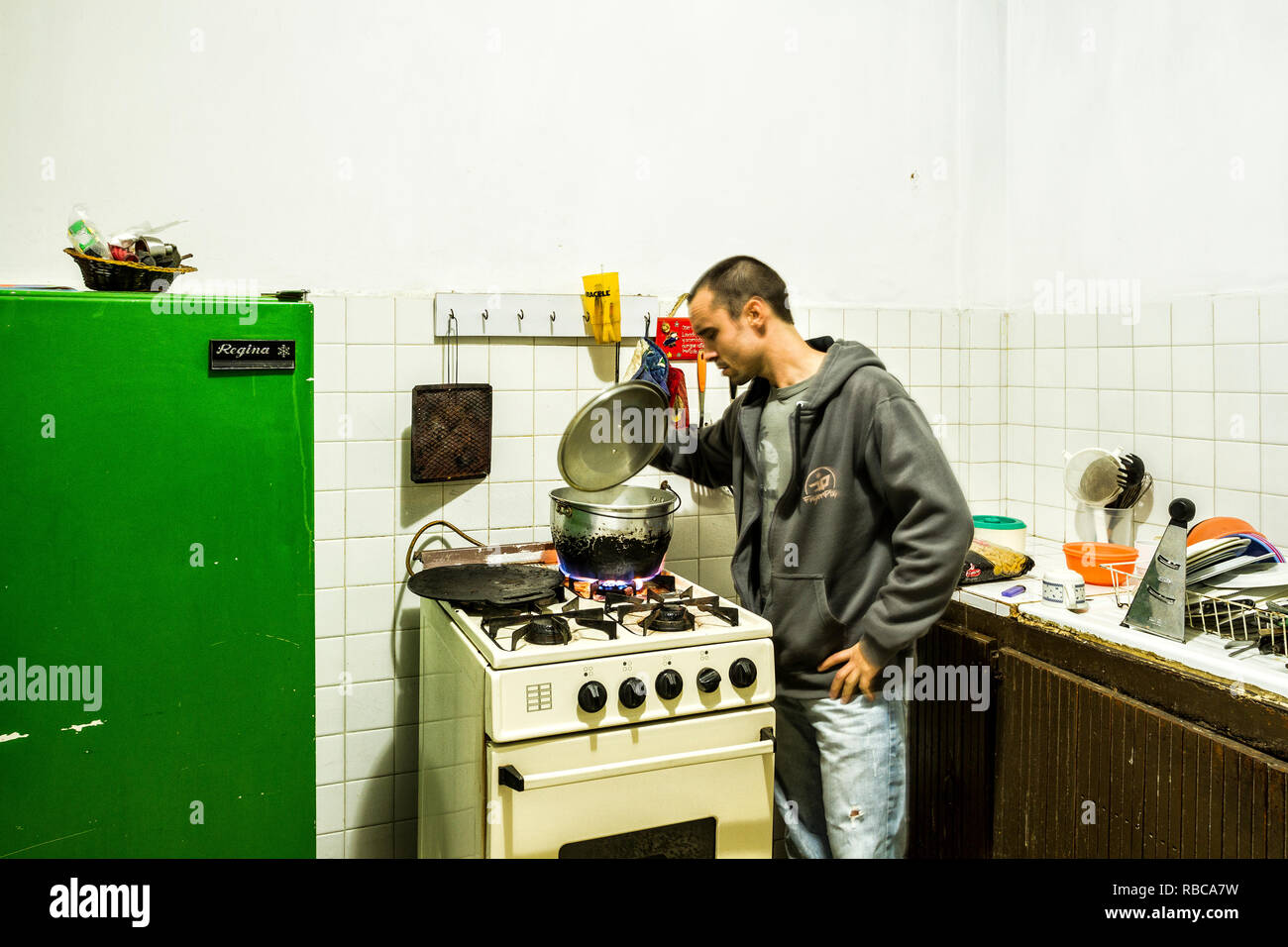 Man cooking in a hostel kitchen. Merida, Merida, Venezuela. Stock Photo