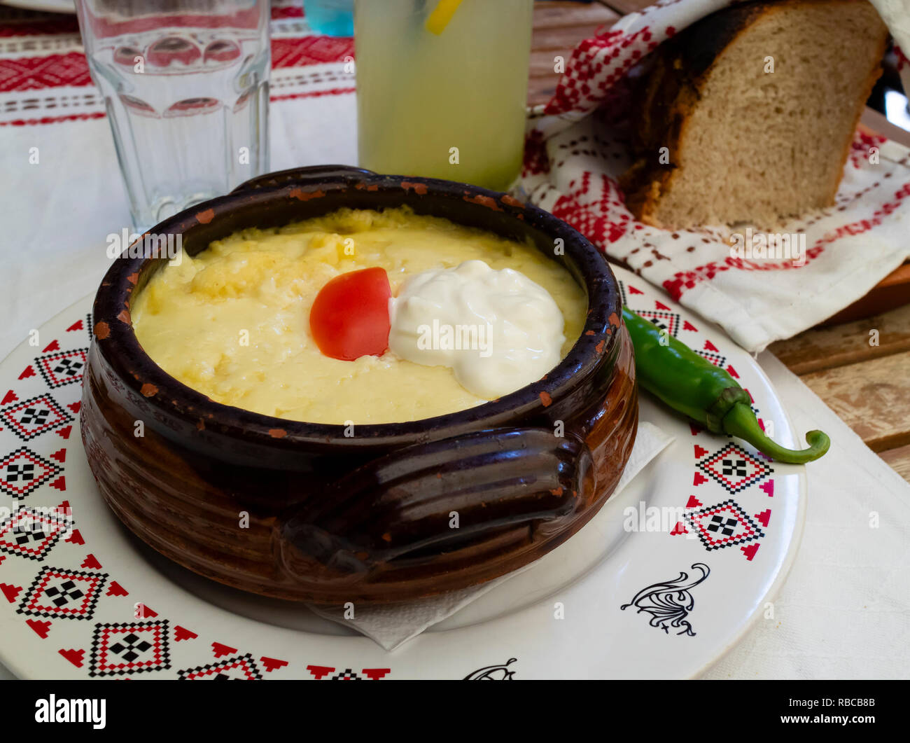 Mamaliga, a traditional romanian dish, made of polenta, served with sour cream and tomato Stock Photo