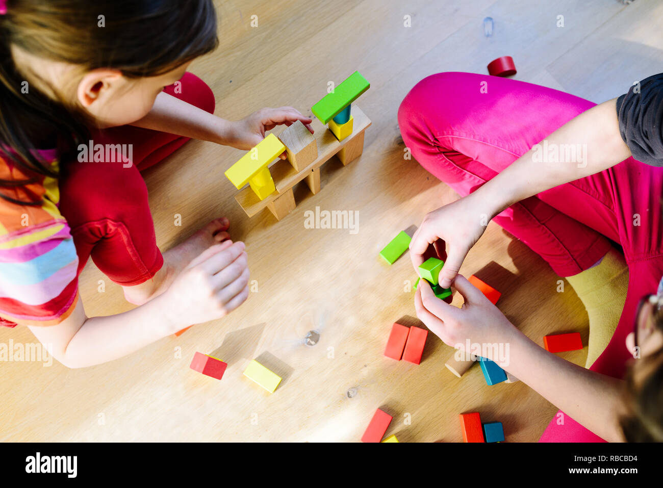 children playing with colorful wooden blocks - view from above Stock ...