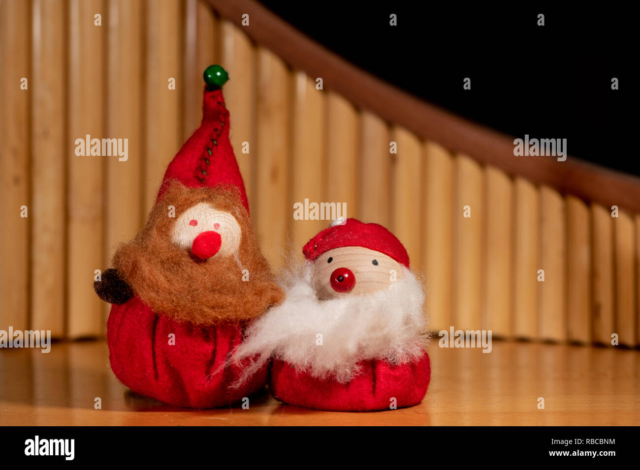 Two handmade puppets of dwarfs with beards sitting on a table in front ...