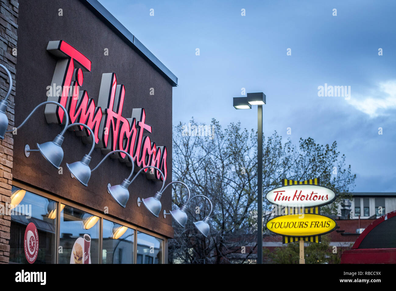 MONTREAL, CANADA - NOVEMBER 6, 2018: Tim Hortons logo in front of one of their restaurants in Quebec with their slogan in French in the background. Ti Stock Photo