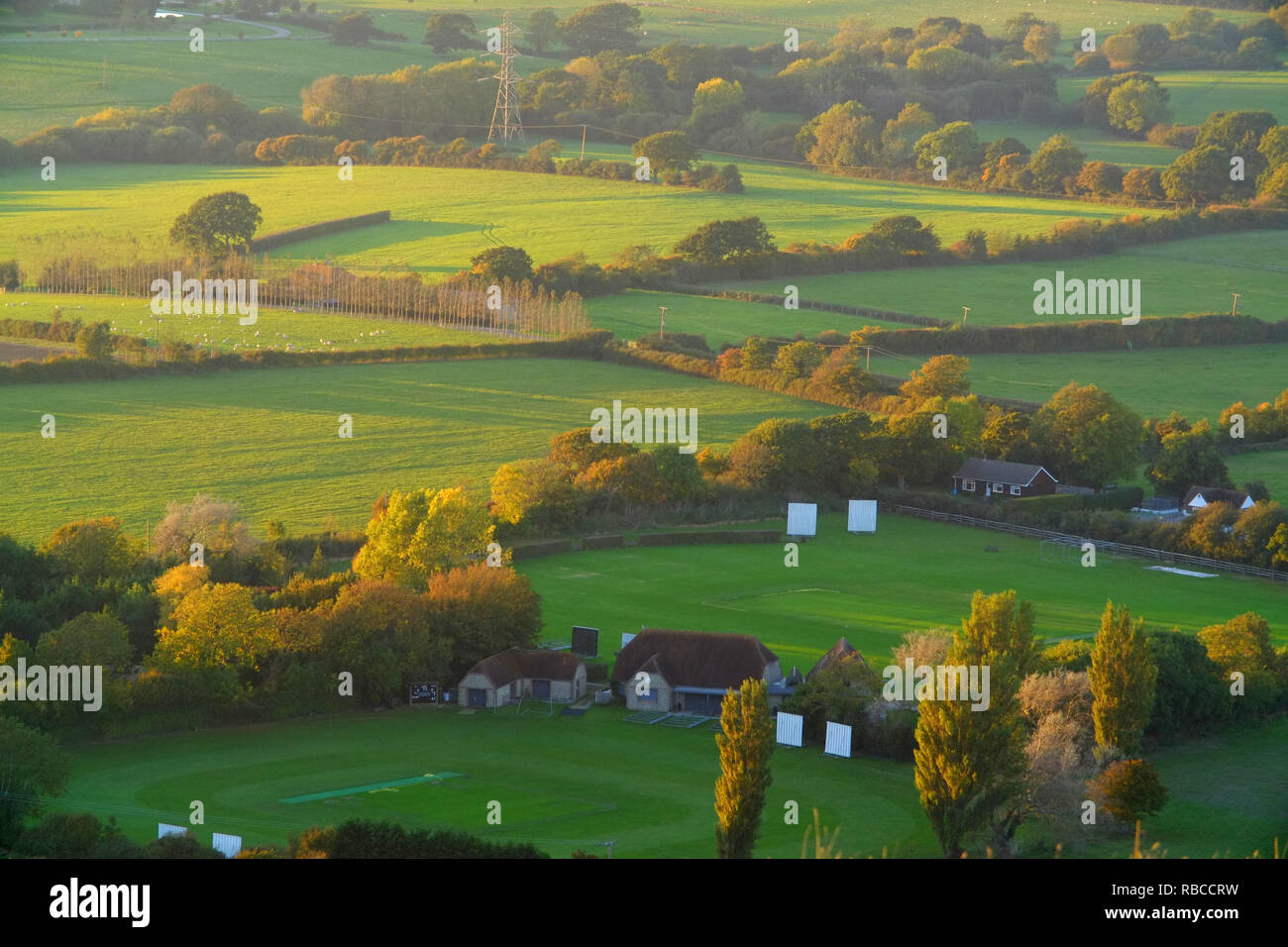 Evening sun over a traditional English Village cricket pitch. Stock Photo