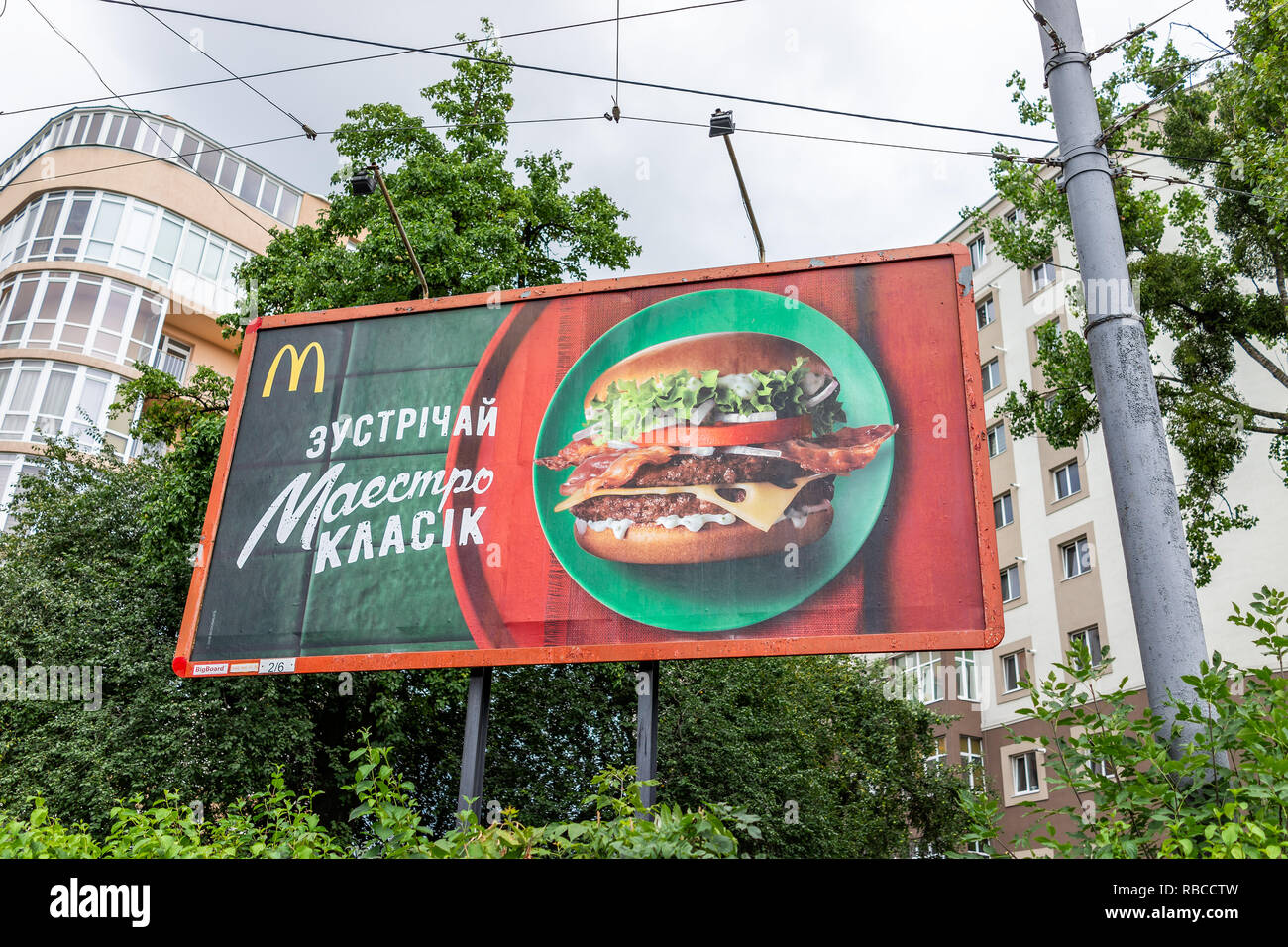 Rivne, Ukraine - July 23, 2018: Closeup of Mcdonalds advertisement ad banner sign in Ukrainian city by street buildings, cyrillic and burger picture Stock Photo