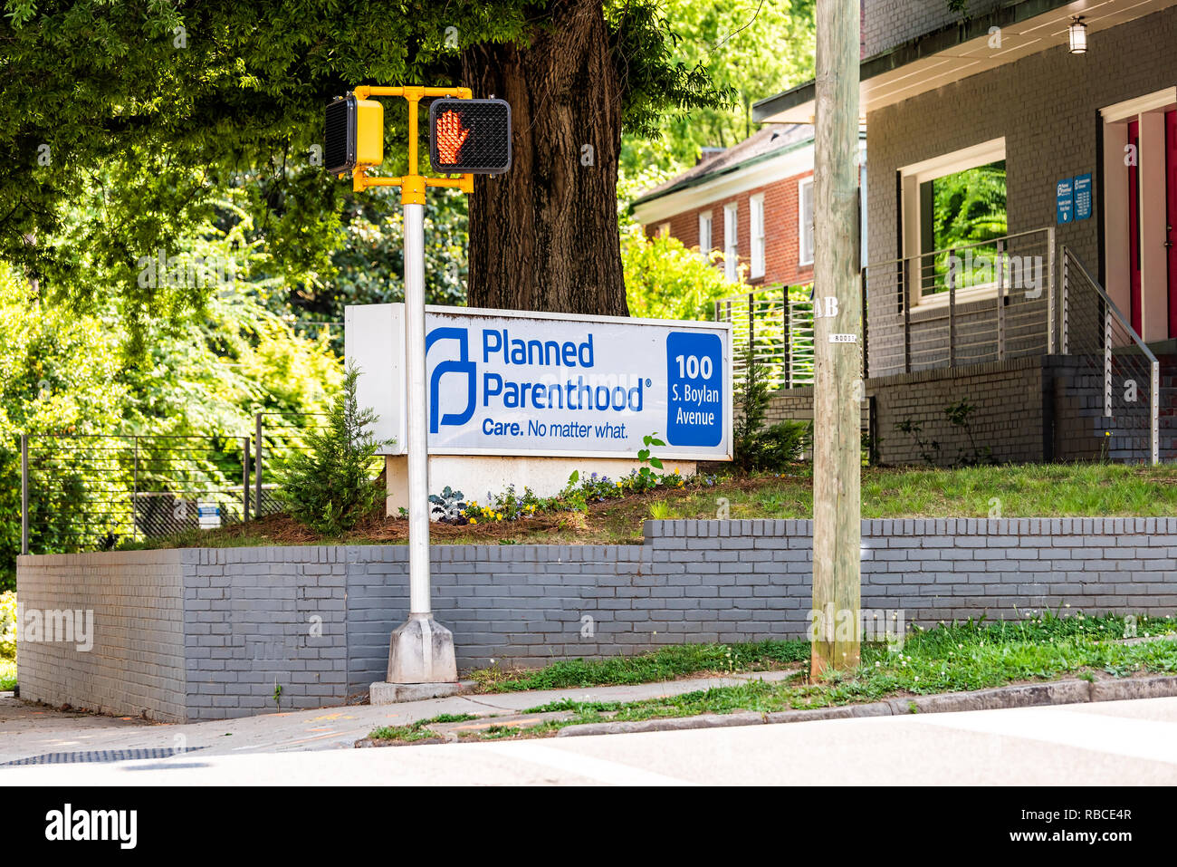 Raleigh, USA - May 13, 2018: Downtown North Carolina city during summer day with pedestrian traffic light on street and planned parenthood building si Stock Photo