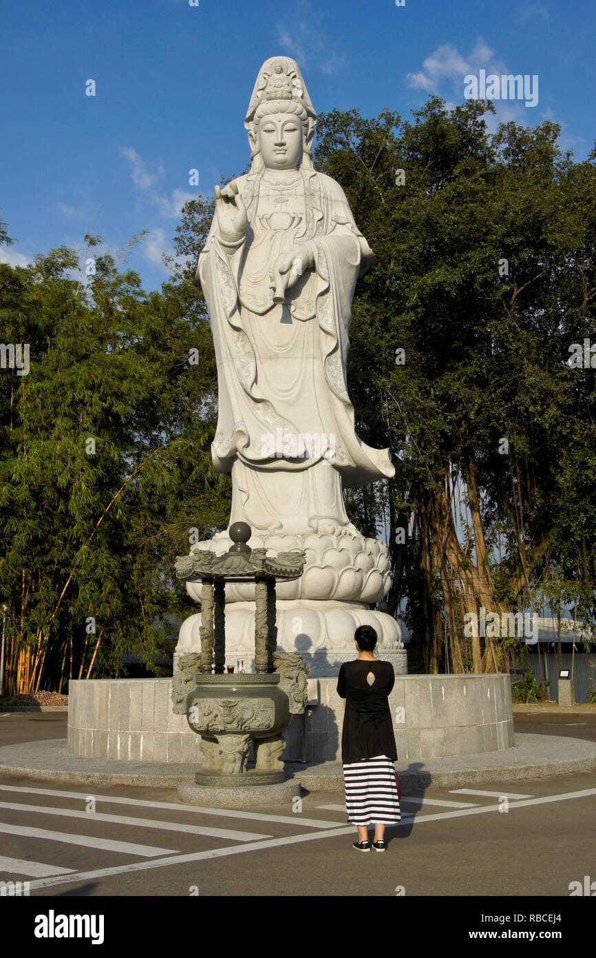 Woman praying at statue of Kwan Yin (Guan Yin), Goddess of Mercy, Puh Toh Tze (Poh Toh Tse, Pu
