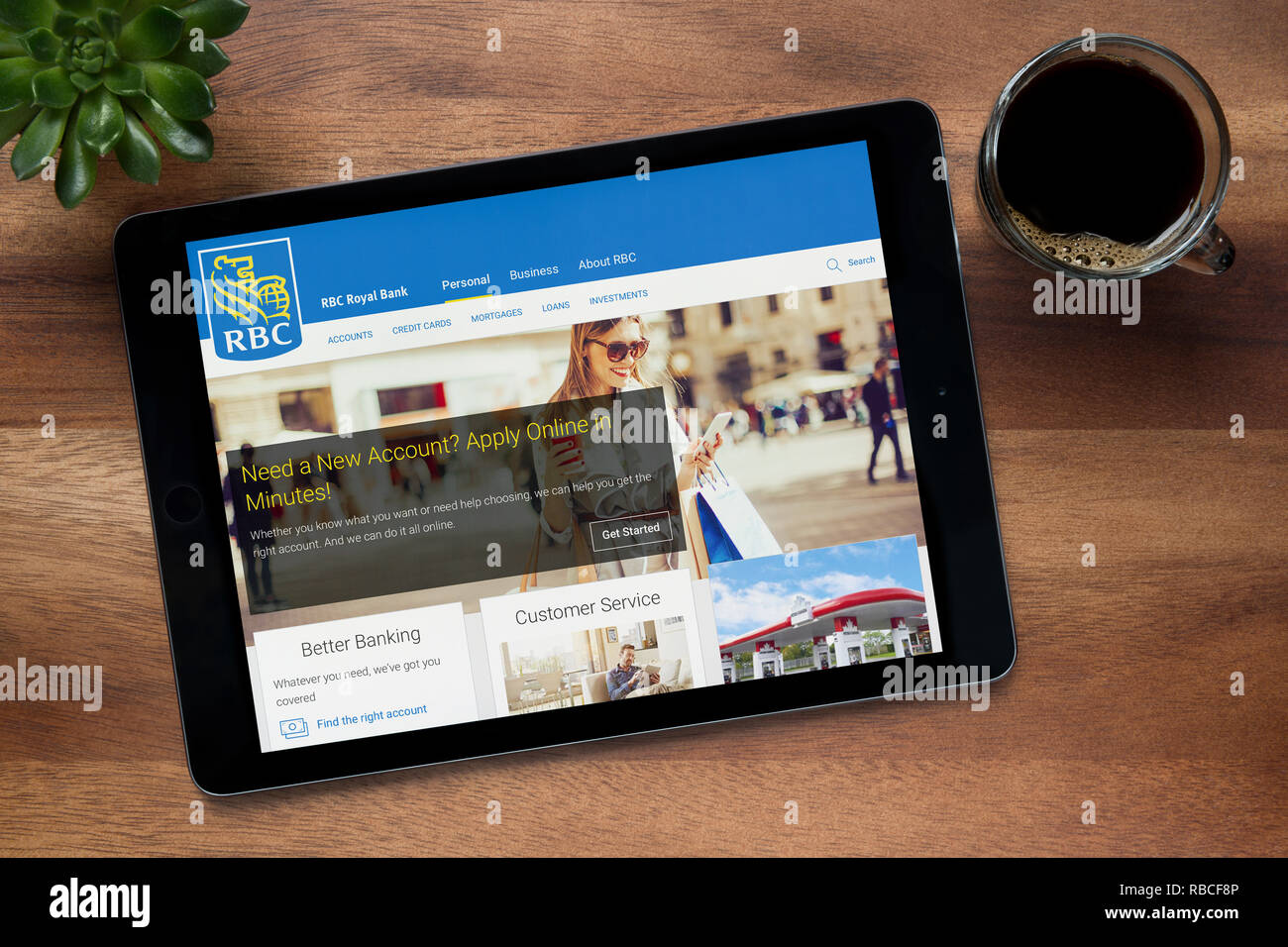 The website of RBC Royal Bank of Canada is seen on an iPad tablet, resting on a wooden (Editorial use only). Stock Photo