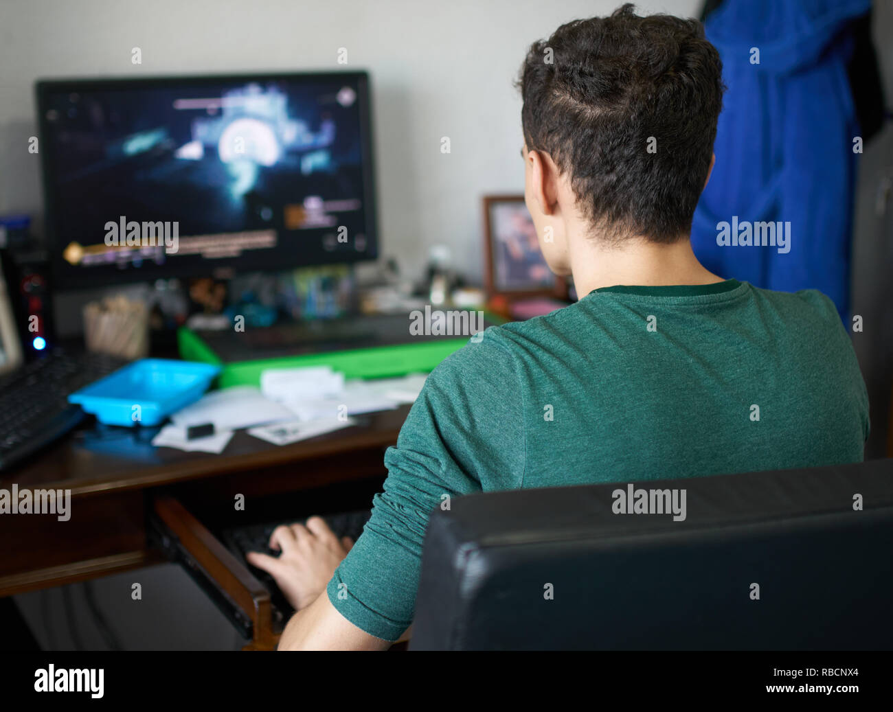 Teenage boy playing computer games at his desk Stock Photo