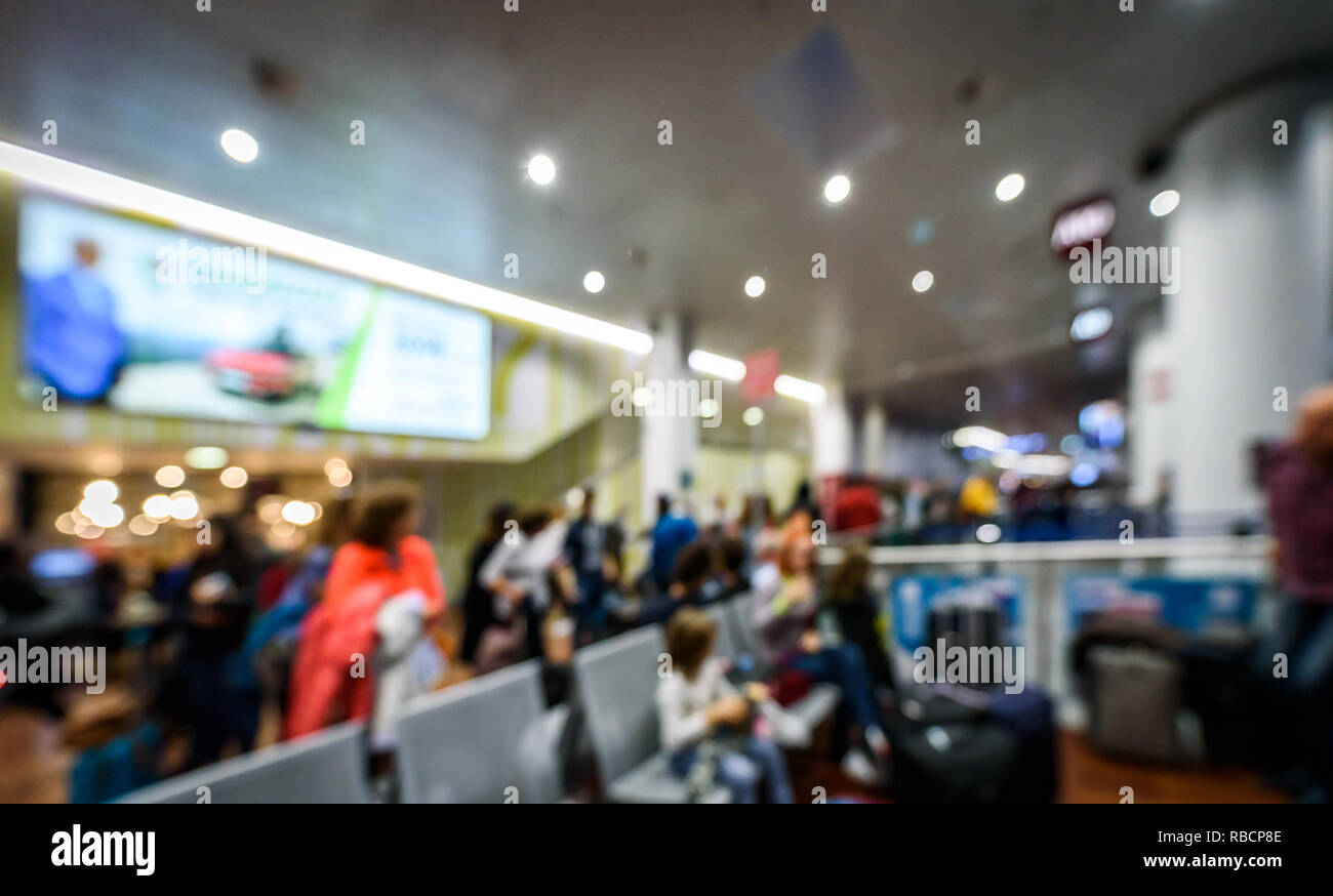 Abstract blurred picture of passengers waiting on the airport. Crowded airport terminal with defocused crowd waiting commercial aeroplane flight in Mi Stock Photo