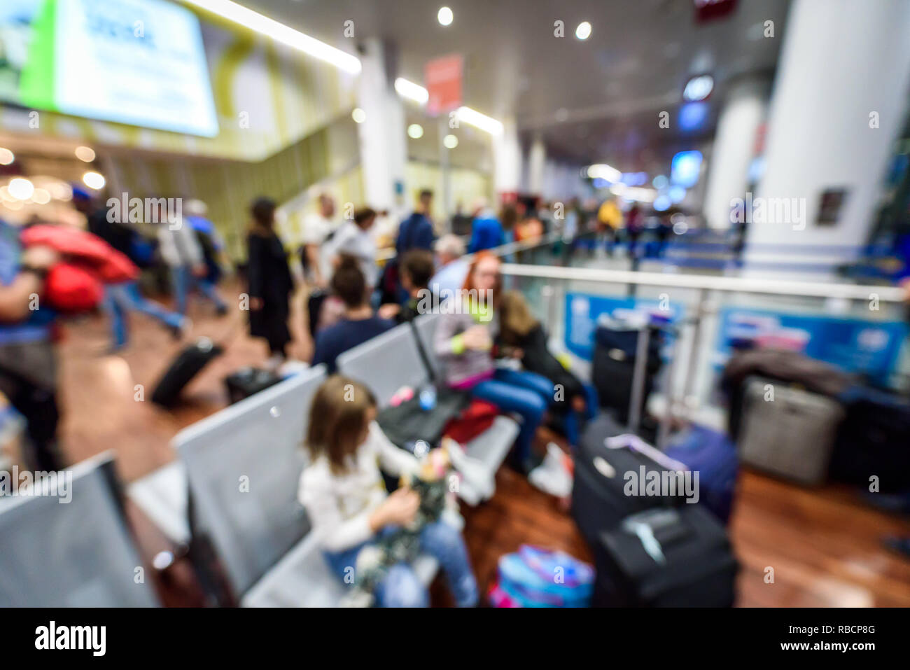 Abstract blurred picture of passengers waiting on the airport. Crowded airport terminal with defocused crowd waiting commercial aeroplane flight in Mi Stock Photo