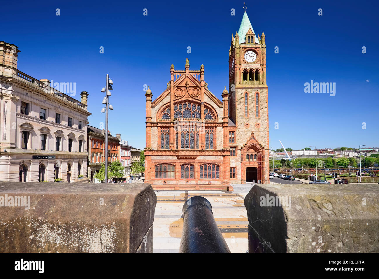 Northern Ireland, County Derry, The Guild Hall, view from the city’s 17th century walls with a cannon in the foreground. Stock Photo