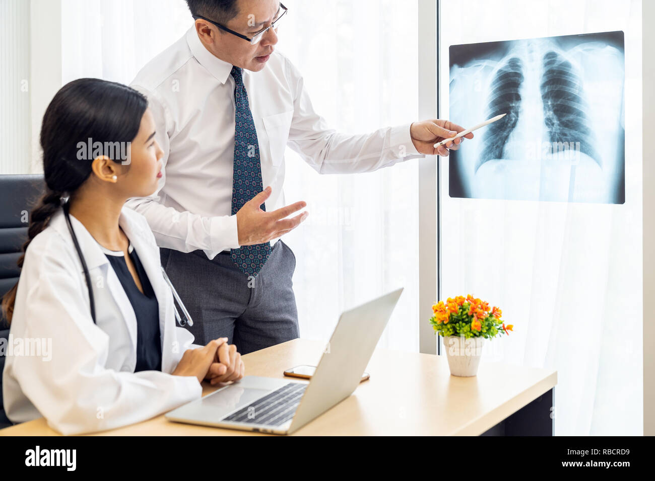 Professional doctors discussion about x-ray result in medical office hospital Stock Photo