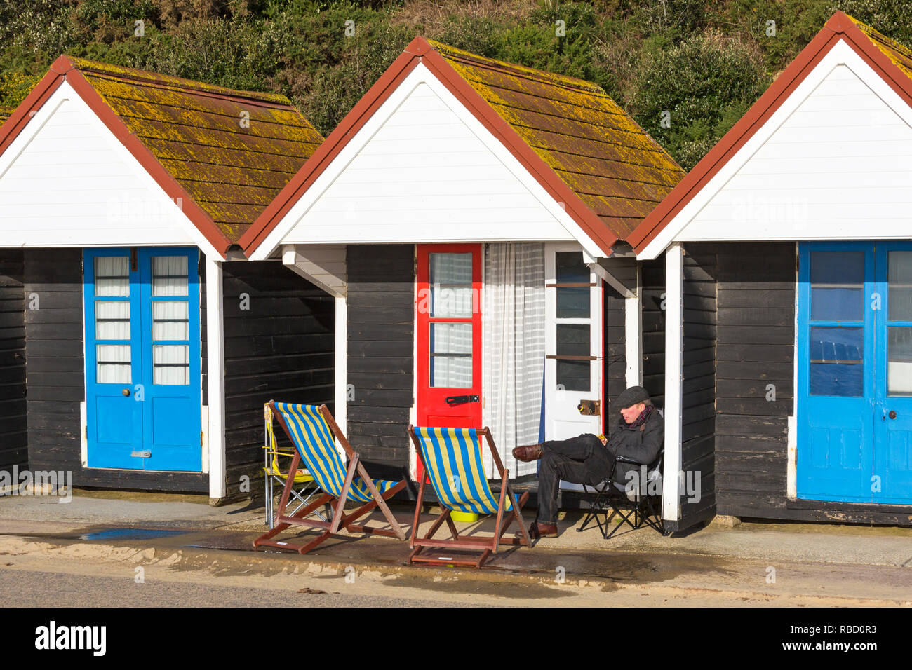 Bournemouth, Dorset, UK. 9th January 2019. Uk weather: sunny with blue skies, although coldish, day at Bournemouth, as visitors head to the beach for some fresh air and exercise. Man sitting outside beach hut. Credit: Carolyn Jenkins/Alamy Live News Stock Photo