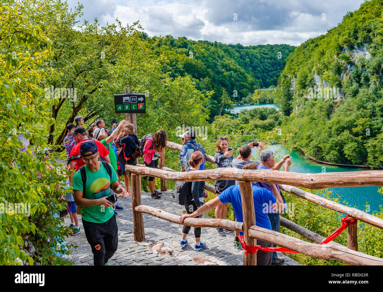 Group of tourists takes pictures of waterfall in Plitvice Lakes National Park, Croatia Stock Photo
