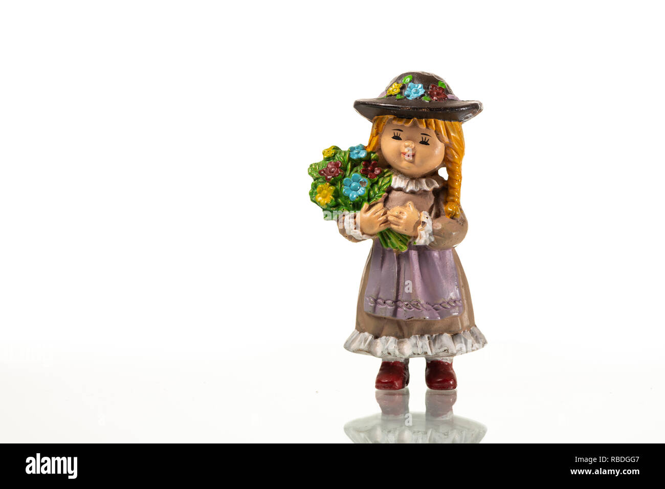 A small figurine of a girl holding flowers, white background Stock Photo