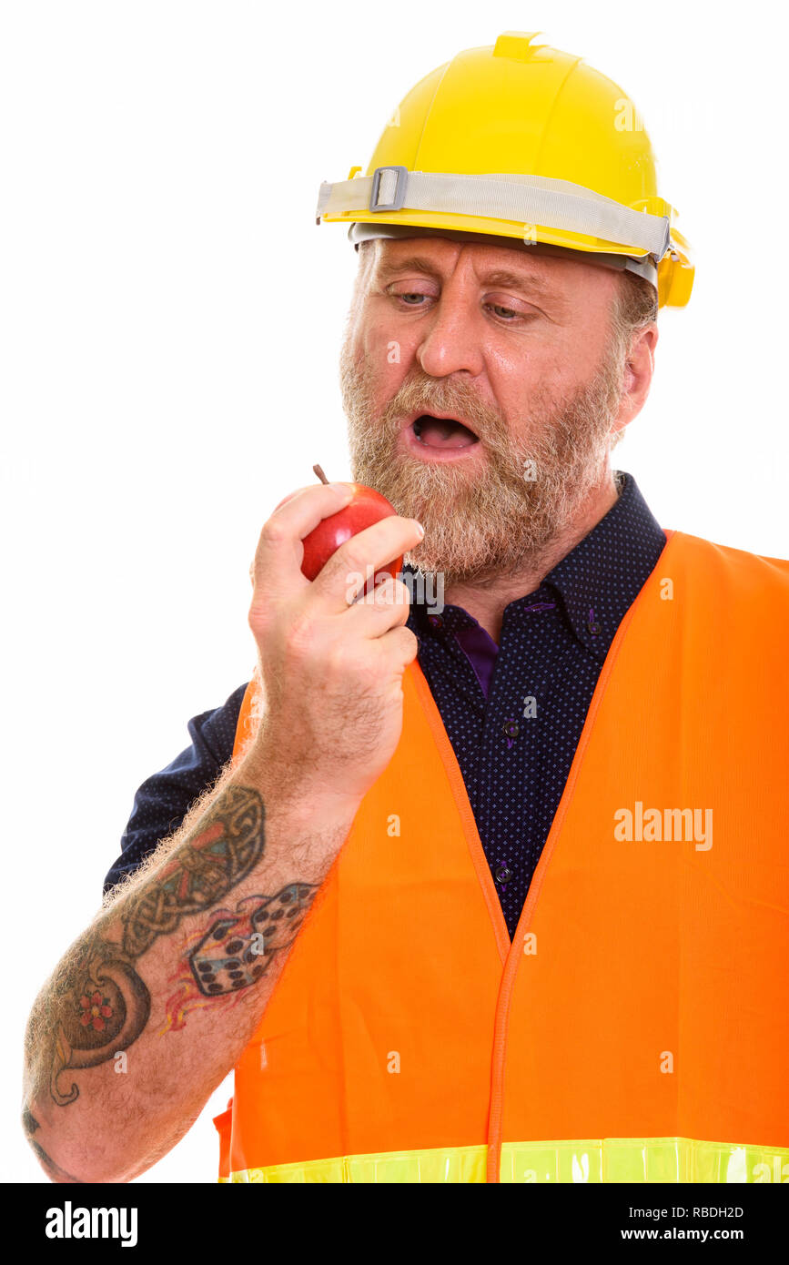 Mature bearded man construction worker eating apple Stock Photo