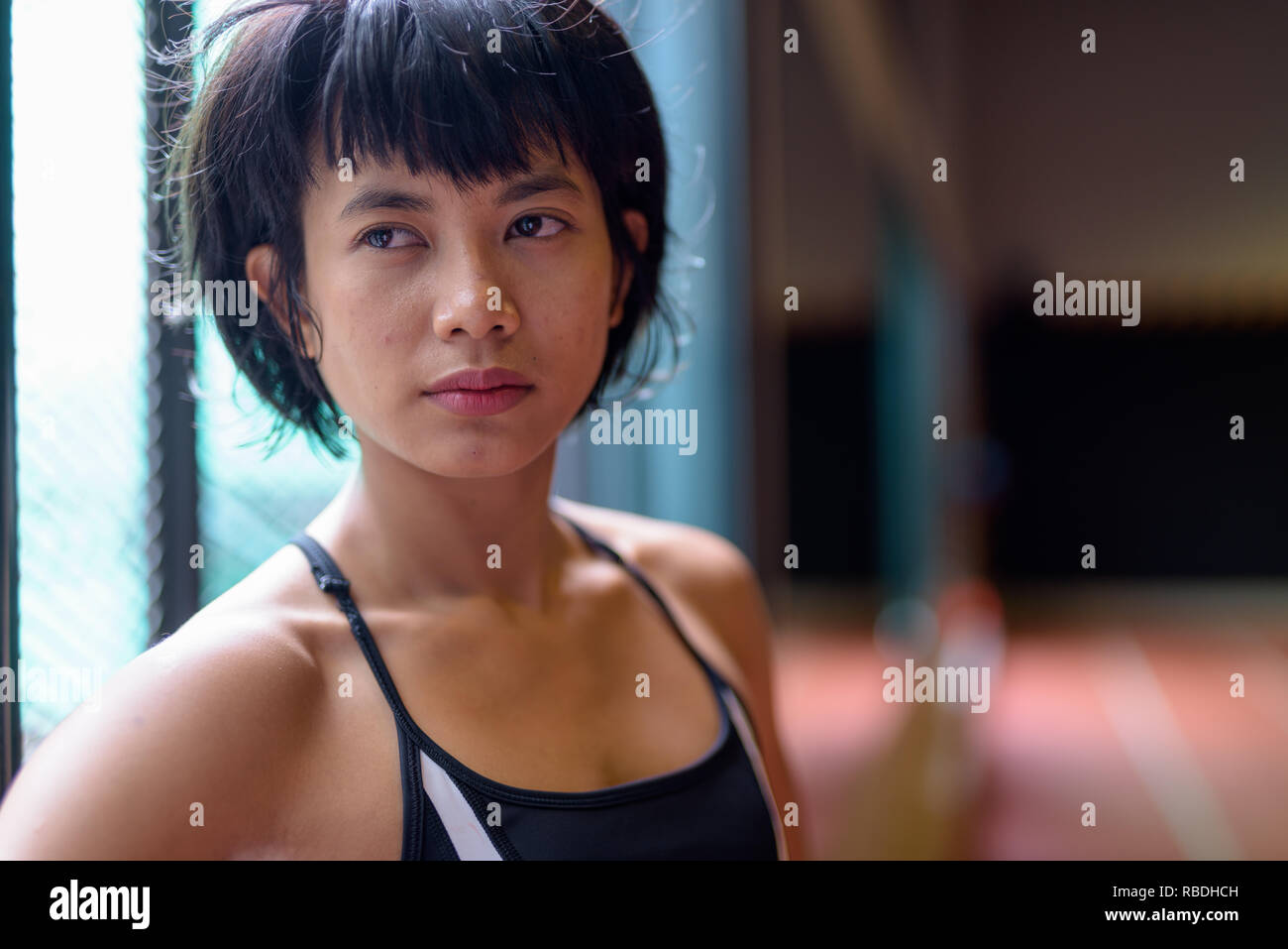 Face of young beautiful Asian woman thinking at the gym Stock Photo