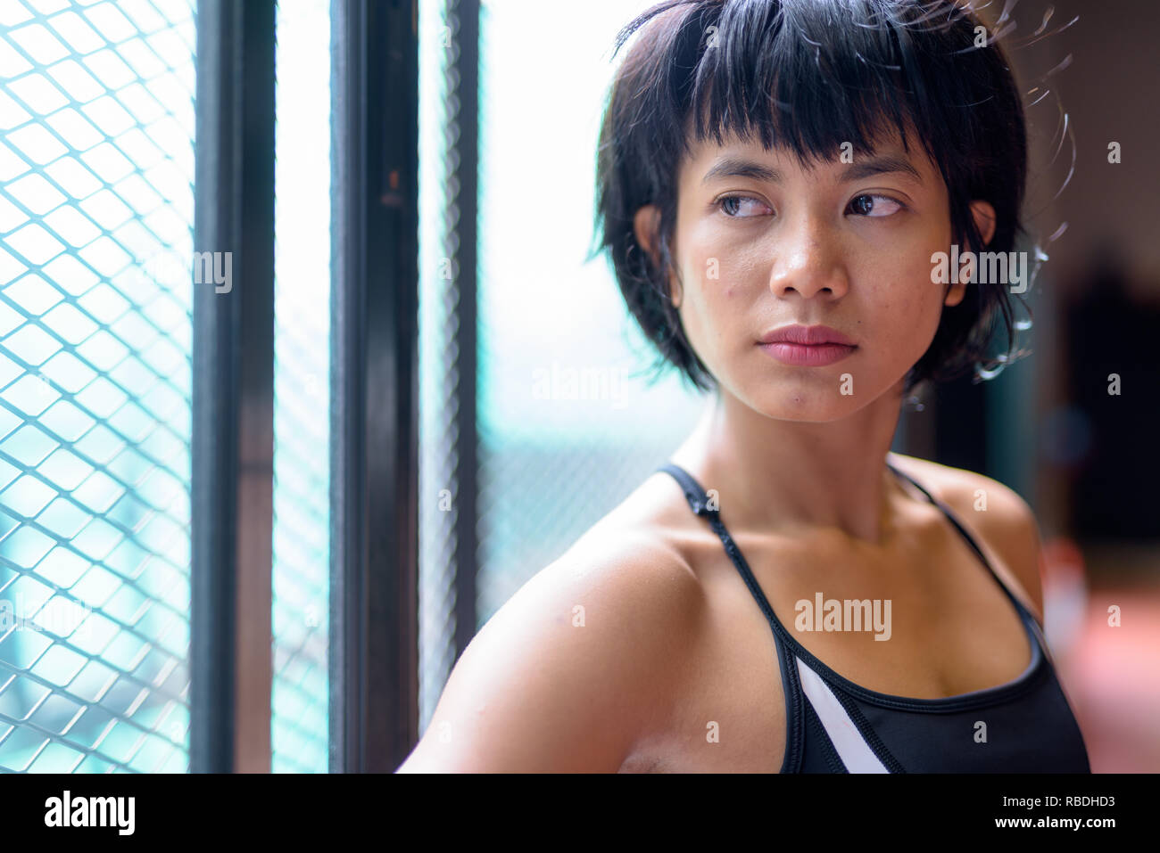 Face of young beautiful Asian woman thinking at the gym Stock Photo