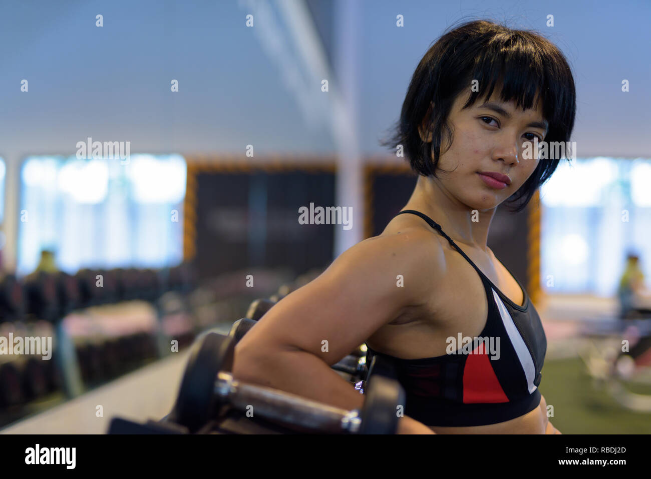 Portrait of young beautiful Asian woman at the gym Stock Photo