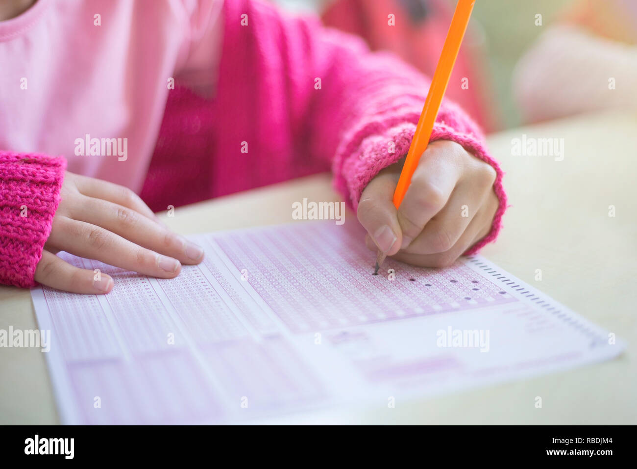 child is marking optical form at the exam Stock Photo