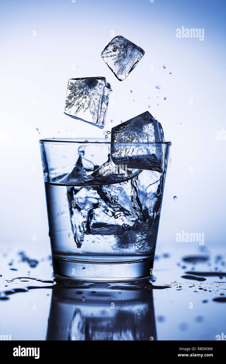 Splash ice cubes in a water glass Stock Photo - Alamy
