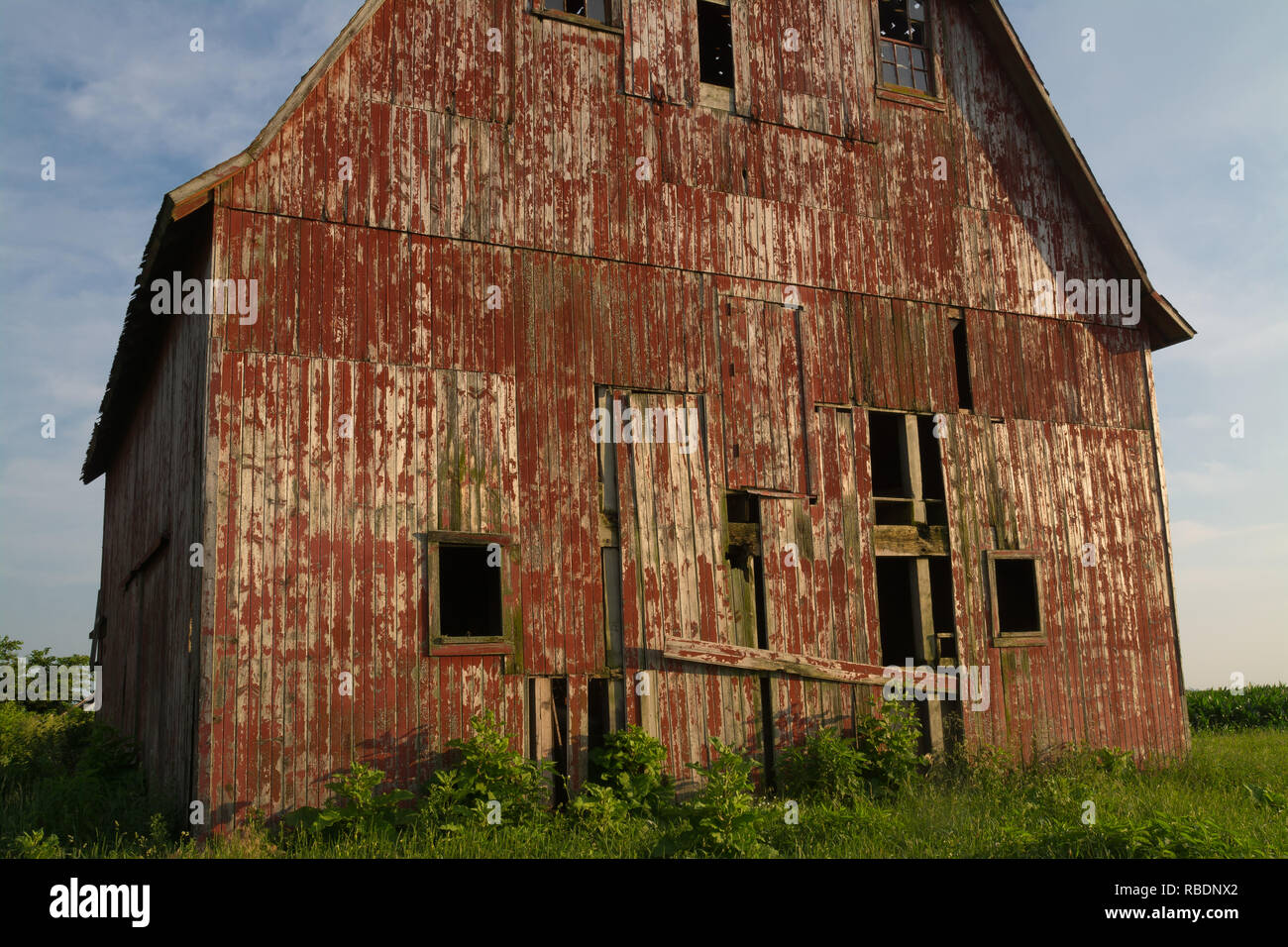 Old wooden red barn in the rural countryside as the sun starts to set ...