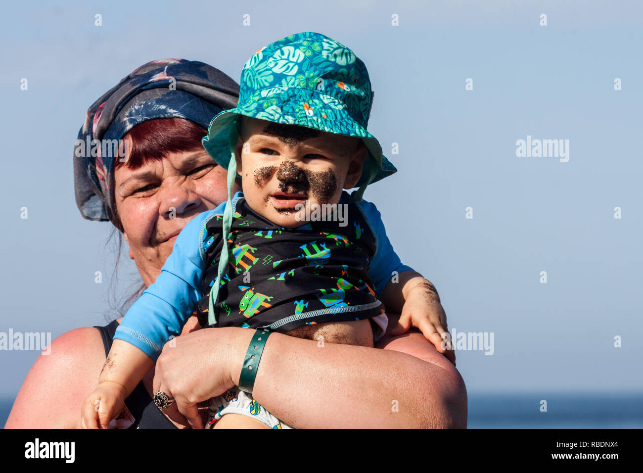 A nice photo of a grandmother holding her dirty faced grandson Stock Photo