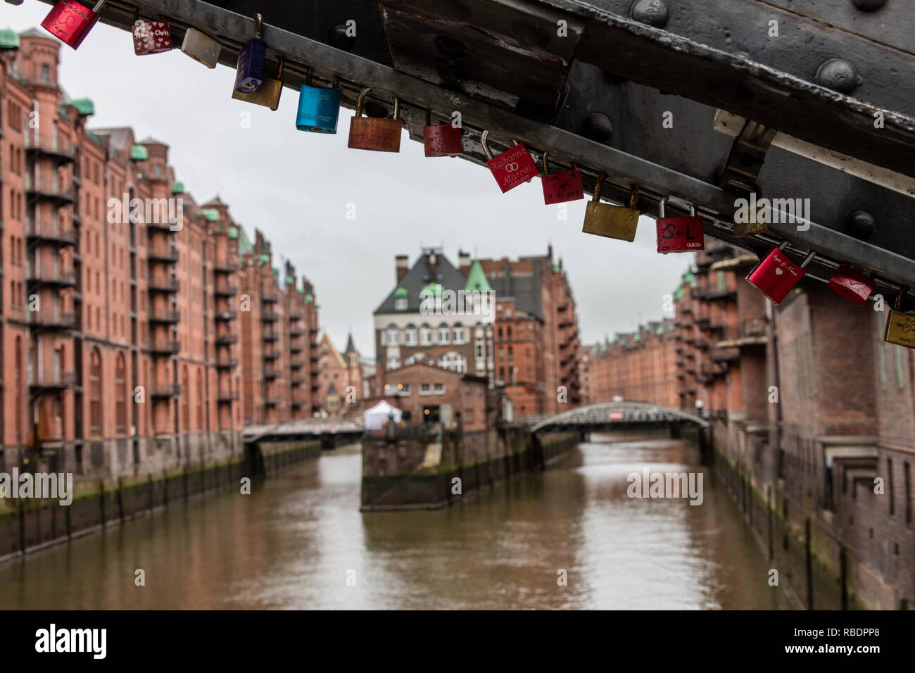 Colorful padlocks on a bridge frame the water castle in the middle of canal, Poggenmhlenbrck, Altstadt Hamburg Germany Europe Stock Photo