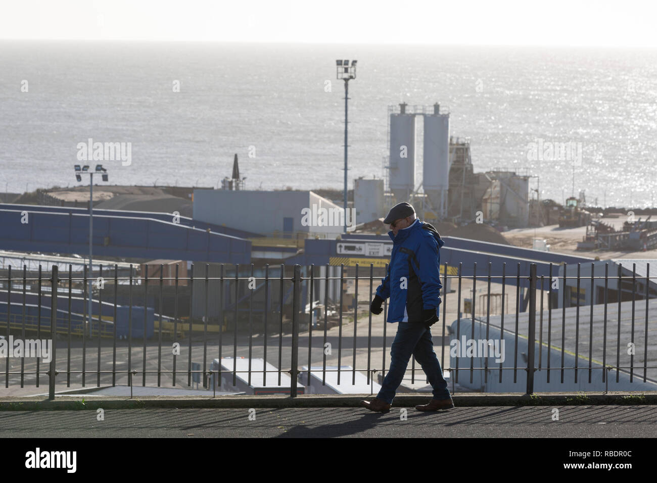 A Kent man walks along West Cliff Promenade that overlooks the Port of Ramsgate, a closed but once busy ferry terminal, on 8th January 2019, in Ramsgate, Kent, England. The Port of Ramsgate has been identified as a 'Brexit Port' by the government of Prime Minister Theresa May, currently negotiating the UK's exit from the EU. Britain's Department of Transport has awarded to an unproven shipping company, Seaborne Freight, to provide run roll-on roll-off ferry services to the road haulage industry between Ostend and the Kent port - in the event of more likely No Deal Brexit. In the EU referendum  Stock Photo
