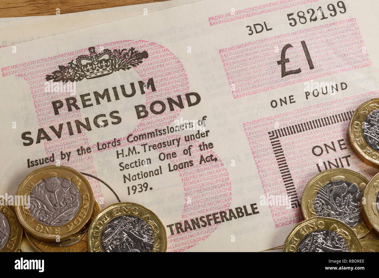 Vintage Premium Bonds with some £1 pound coins Stock Photo