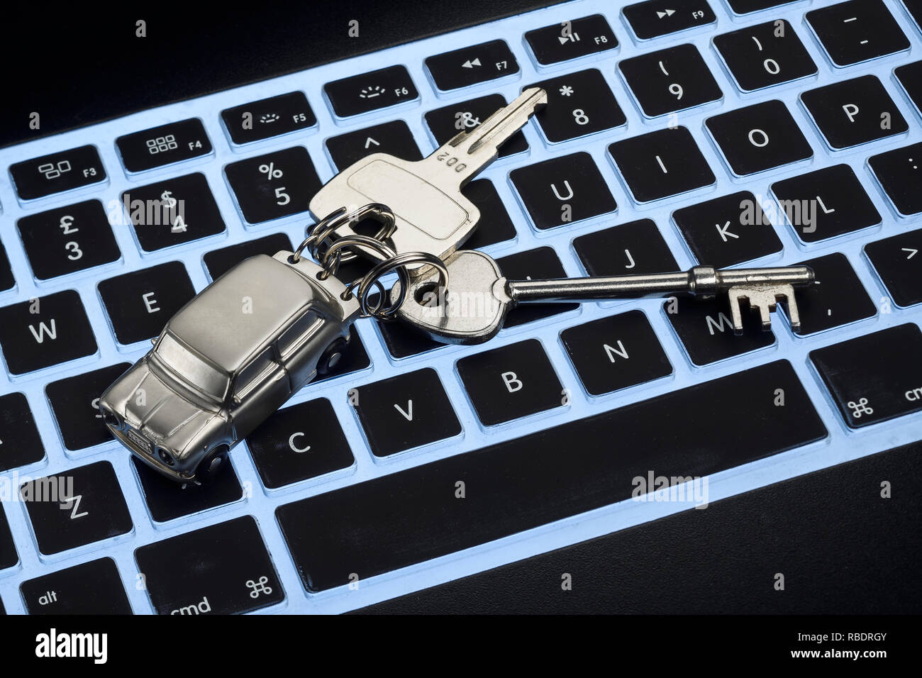 A computer keyboard with a set of car keys Stock Photo