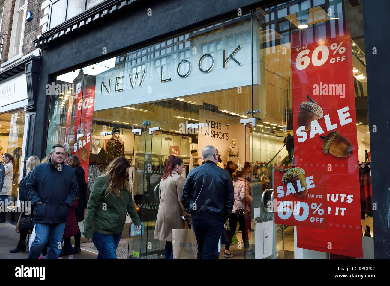 Shoppers walking past the Chester branch of New Look with sale signs in the window Stock Photo