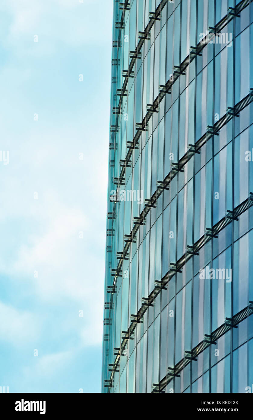 Background texture of modern business skyscraper building glass windows pattern with reflection over cloudy blue sky, low angle view Stock Photo