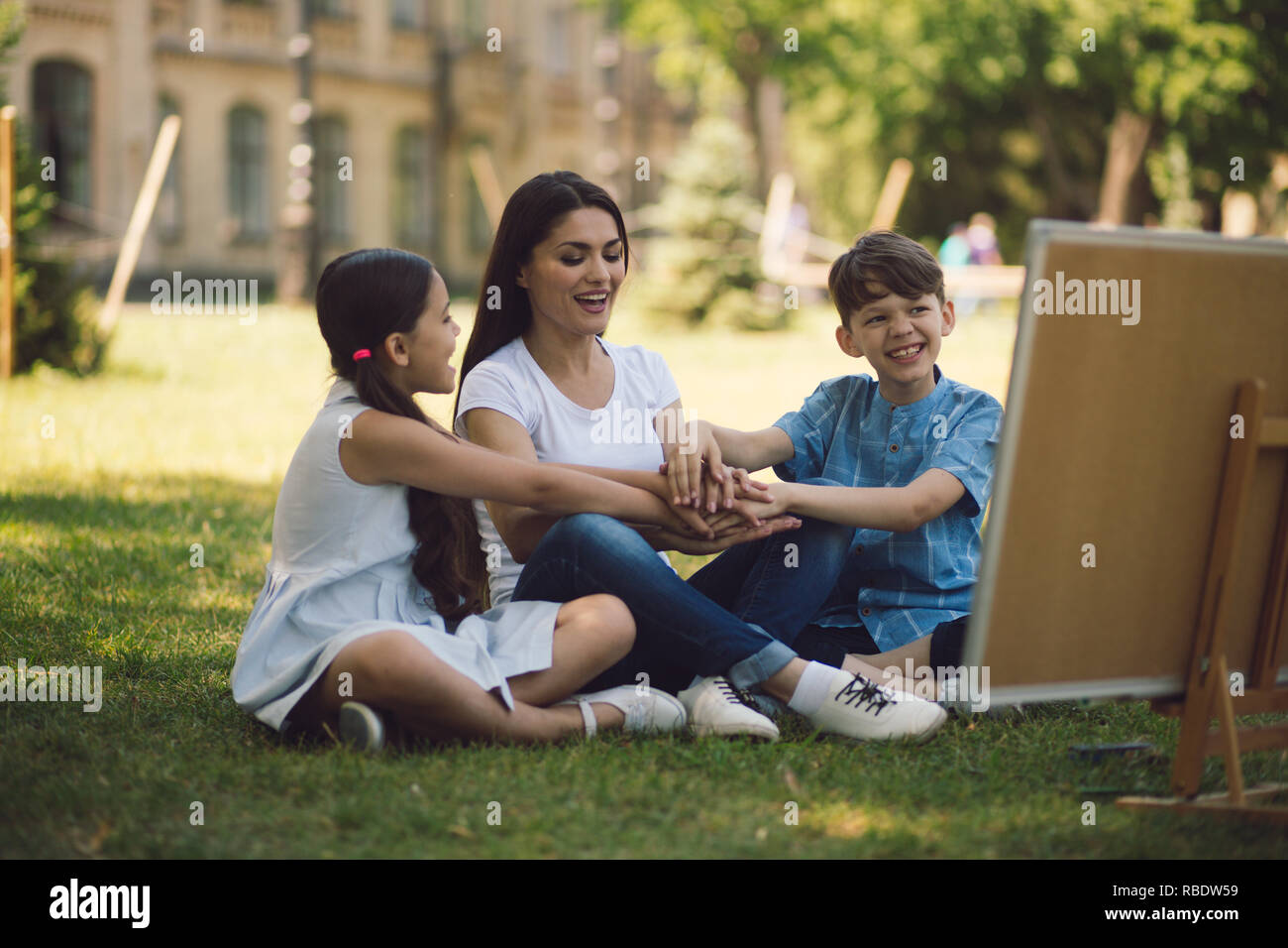 Children and teacher posing with raised hands Stock Photo - Alamy